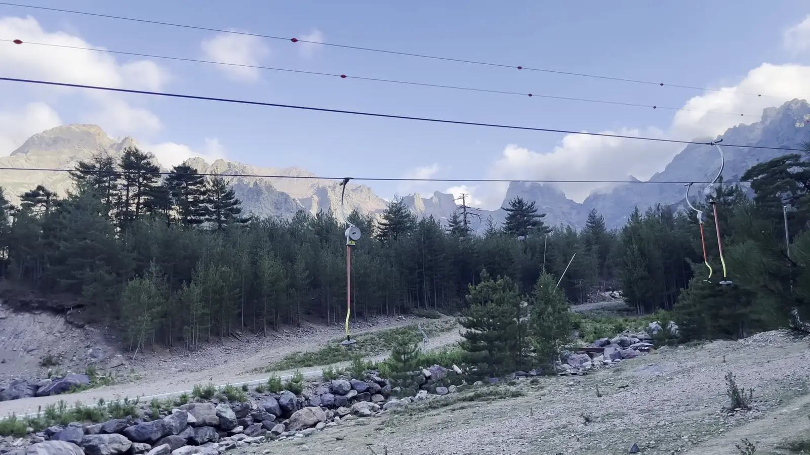 Téléski de la station de Haut Asco, forêt de pins et aiguilles rocheuses sous les nuages